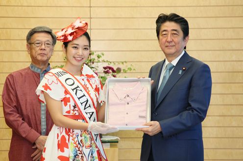 Photograph of the Prime Minister being presented with a kariyushi shirt