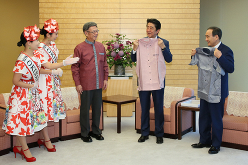 Photograph of the Prime Minister and the Chief Cabinet Secretary being presented with a kariyushi shirt