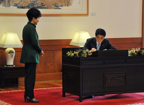 Photograph of the Prime Minister signing a book