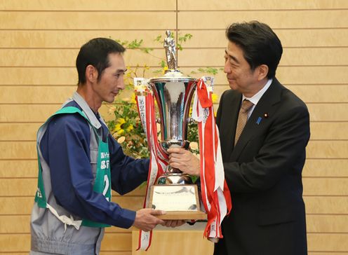 Photograph of the Prime Minister presenting a trophy