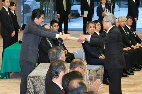 Photograph of the Prime Minister presenting an award