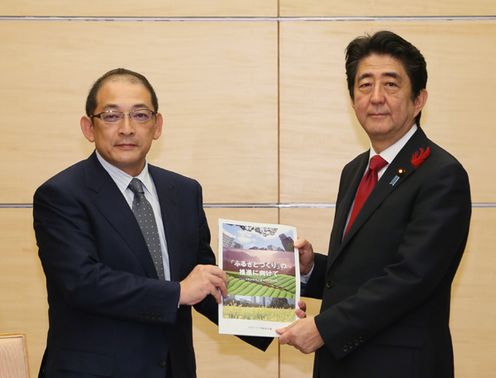 Photograph of the Prime Minister receiving the brochure