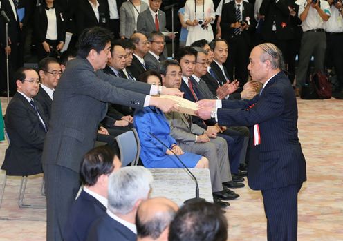 Photograph of the Prime Minister presenting a certificate of award