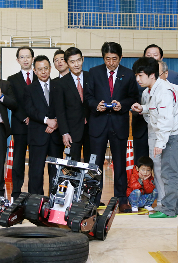 Photograph of the Prime Minister operating a robot at the robot and drone class