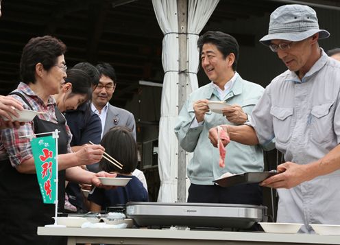 Photograph of the Prime Minister tasting local beef