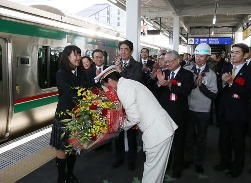 Photograph of the Prime Minister attending the presentation of a bouquet on a platform in JR Shinchi Station