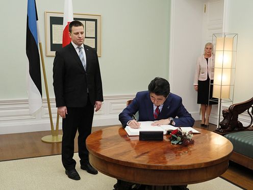 Photograph of the Prime Minister signing a book prior to the summit meeting