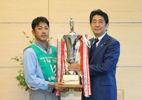 Photograph of the Prime Minister presenting a trophy