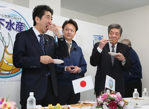 Photograph of the Prime Minister sampling fishery processing plant products