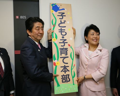 Photograph of the Prime Minister raising a signboard