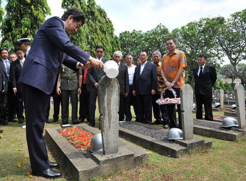 Photograph of the Prime Minister offering water at a Japanese cemetery