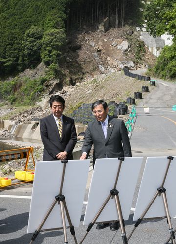 Photograph of the Prime Minister receiving an explanation from Governor Nisaka of Wakayama Prefecture on the state of repairs of National Route 311 at a section damaged by a natural disaster