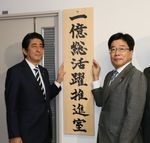 Photograph of the Prime Minister raising a signboard