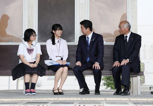 Photograph of the Prime Minister receiving an explanation about the initiatives of survivors who share their experiences