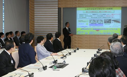 Photograph of the Prime Minister listening to an explanation