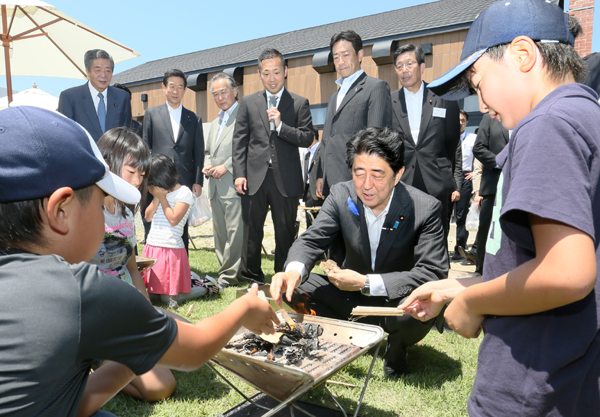 Photograph of the Prime Minister testing out a disaster relief fire-starting kit