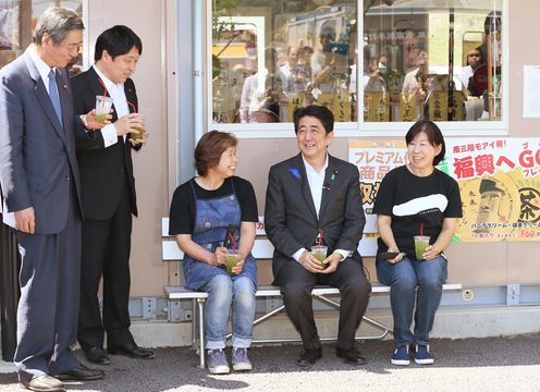 Photograph of the Prime Minister reuniting with people working in the temporary shopping area, the Minamisanriku Sun Sun Shopping Village