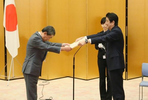 Photograph of the Prime Minister presenting a certificate of award