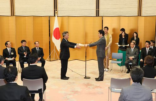 Photograph of the Prime Minister presenting a certificate of award