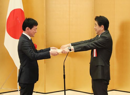 Photograph of the Prime Minister presenting a certificate of award