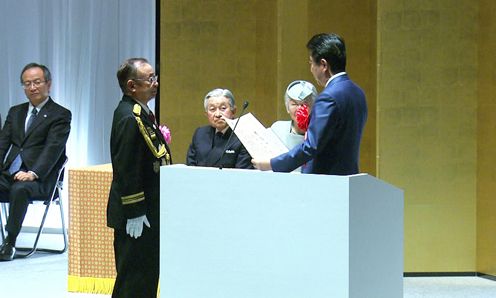 Photograph of the Prime Minister presenting a certificate of award