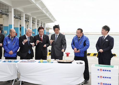 Photograph of the Prime Minister tasting food at the Matsukawaura fishing port (2)