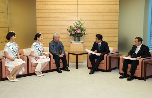 Photograph of the Prime Minister being presented with a kariyushi shirt