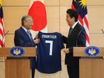 Photograph of the Prime Minister presenting a uniform of the Japan national soccer team