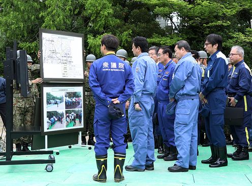 Photograph of the Prime Minister receiving an explanation of bathing support and other activities provided by Self-Defense Force members