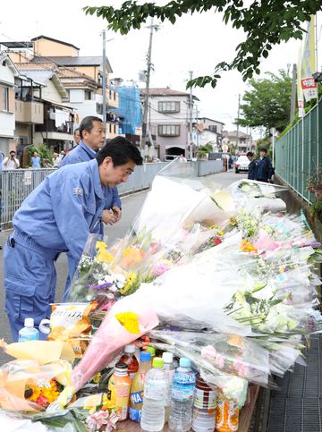 Photograph of the Prime Minister offering flowers at the site of the collapsed concrete wall