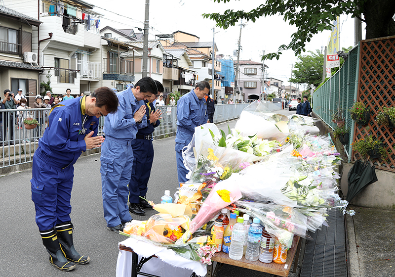 Photograph of the Prime Minister offering flowers at the site of the collapsed concrete wall