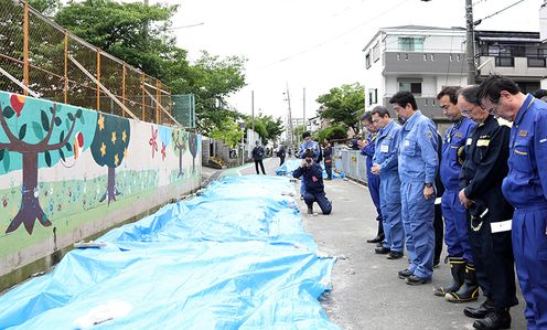 Photograph of the Prime Minister offering a silent prayer at the site of the collapsed concrete wall 