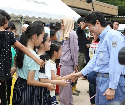 Photograph of the Prime Minister listening to those affected by the disaster