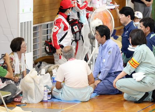 Photograph of the Prime Minister listening to those affected by the disaster