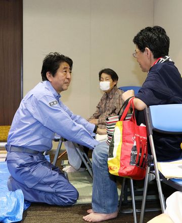 Photograph of the Prime Minister listening to those affected by the disaster