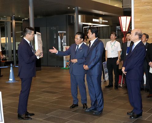 Photograph of the Prime Minister receiving an explanation at Toyama Station