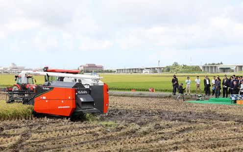 Photograph of the Prime Minister watching a demonstration of the self-driving combine harvester and tractor 