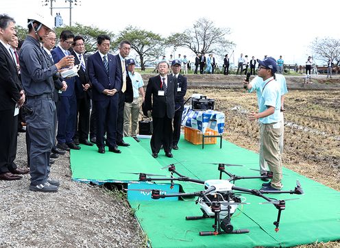 Photograph of the Prime Minister watching a demonstration of the automatic spraying of agrochemicals using a drone