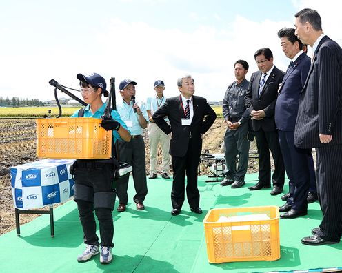 Photograph of the Prime Minister watching a demonstration of the power-assisted suit