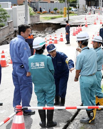 Photograph of the Prime Minister visiting a site affected by liquefaction