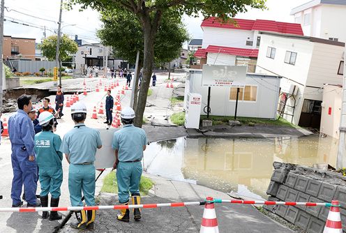 Photograph of the Prime Minister visiting a site affected by liquefaction