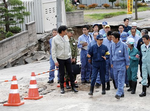 Photograph of the Prime Minister visiting a site affected by liquefaction