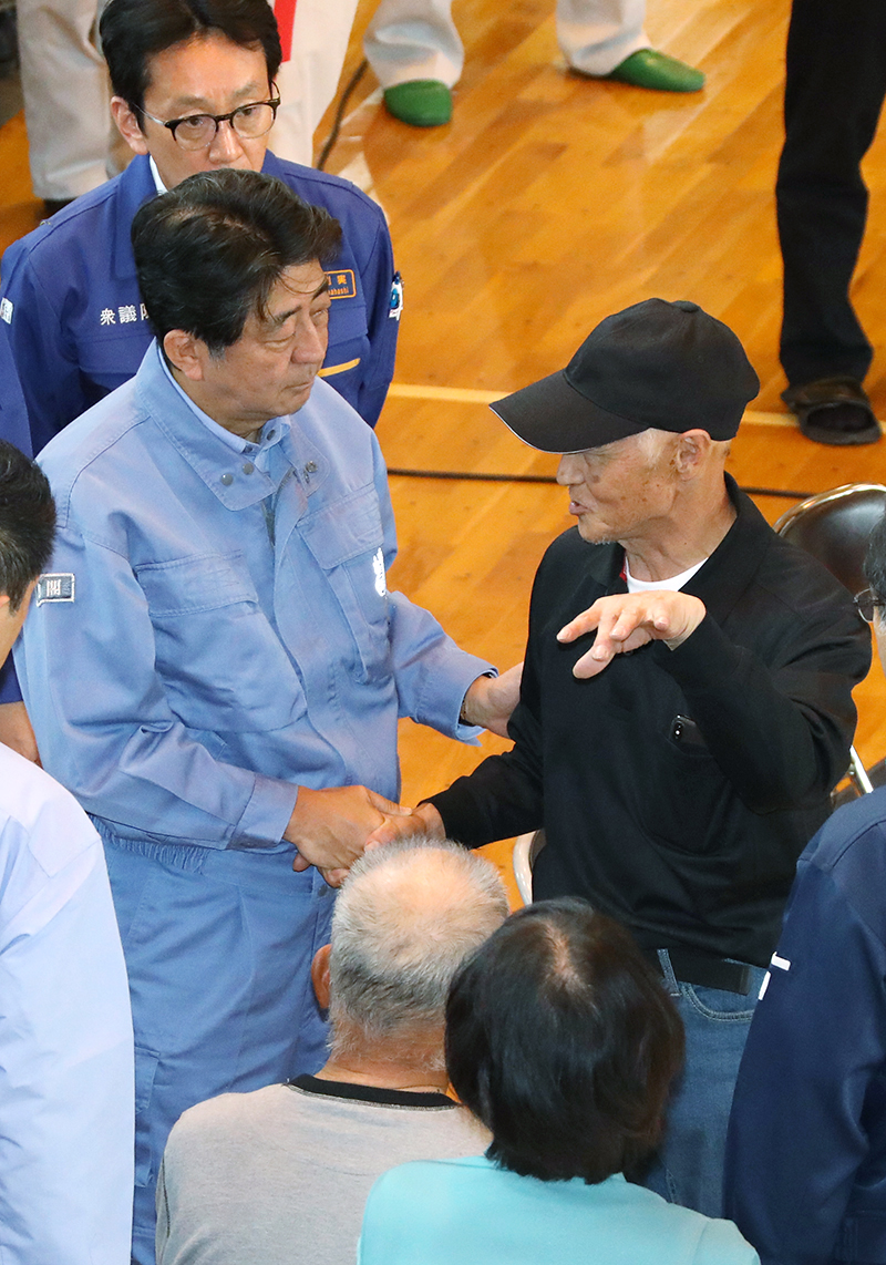 Photograph of the Prime Minister listening to those affected by the disaster at an evacuation center in Atsuma Town