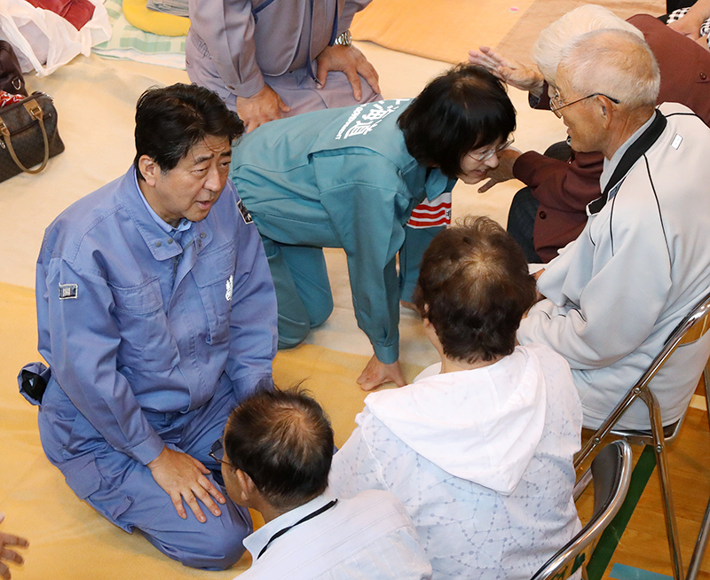 Photograph of the Prime Minister listening to those affected by the disaster at an evacuation center in Atsuma Town