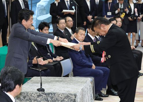 Photograph of the Prime Minister presenting a certificate of award