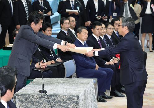 Photograph of the Prime Minister presenting a certificate of award