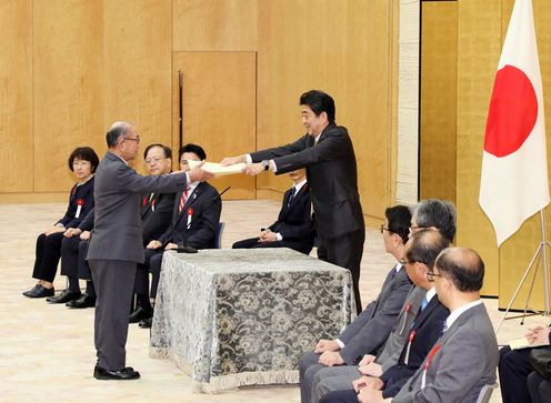 Photograph of the Prime Minister presenting a certificate of award