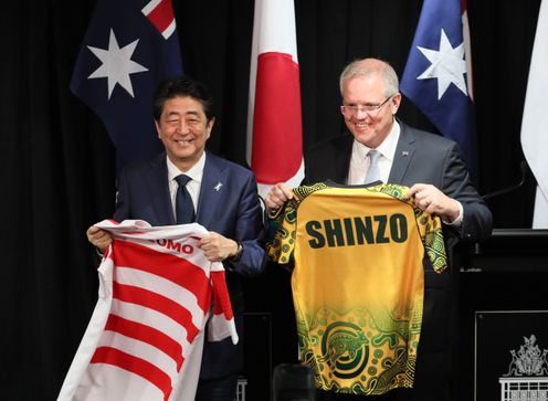 Photograph of the leaders exchanging national rugby jerseys