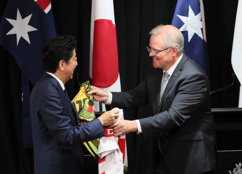 Photograph of the leaders exchanging national rugby jerseys