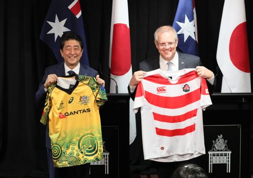 Photograph of the leaders exchanging national rugby jerseys